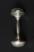 An early 20th century silver plate twin end babies rattle having decorative design.