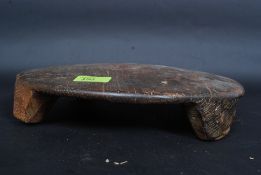 A 20th century Indian carved wooden circular chipati board raised on feet to edges