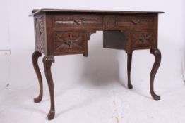A good 20th century carved country oak Queen Anne style writing table desk raised on cabriole legs