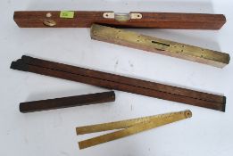 A collection of vintage measures to include rules and spirit level.