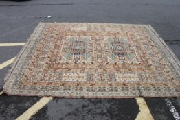 A 20th century beige Persian rug of large size having tree of life pattern borders with tassled