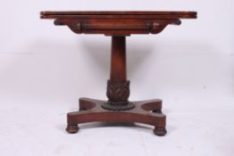 A Regency mahogany card / games table raised on a quadruped base having acanthus leaf carved column