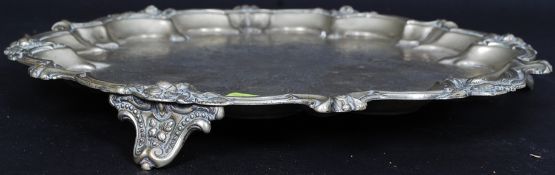 A 19th century Paktong ? white metal engraved salver of scalloped form having shaped feet beneaths