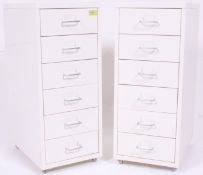 A pair of retro style white metal upright pedestal filing cabinets having chrome hoop handles to