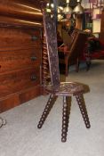 An early 20th century carved oak spinning chair being raised on bobbin turned supports with caved