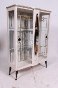 A retro 1950's upcycled display cabinet having painted exterior with glass sliding doors together