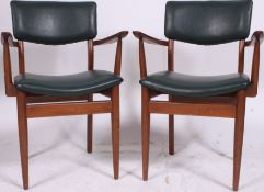 A pair of vintage 1970's teak wood retro mid century carver office dining chairs with shaped elbow