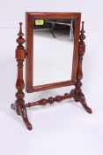 A Victorian mahogany toilet swing mirror having column supports with central rectangular mirror