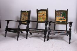 A set of 3 Indian ebonised and handpainted folding chairs.
