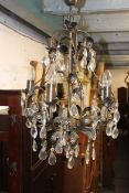 A 20th century unwrapped rococo and metal glass chandelier having leaf finish with electric mounts