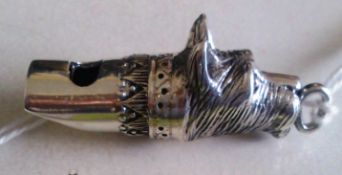 A vintage white metal (stamped 925 for silver ) dog whistle in the form of a dogs head.