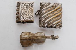 Three vintage silver plated on brass vestas one in the form of a book another in the form of a