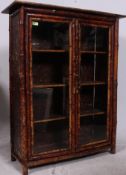 A Victorian aesthetic movement bamboo bookcase display cabinet having twin glazed doors with three