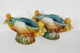 A fabulous pair of 19th century continental large majolica vases adorned with cherubs surrounding