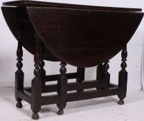 A 19th century drop leaf country oak dining table being peg jointed having gateleg supports with
