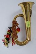 A 20th century Brass bugle instrument with military insignia and rope ties etc