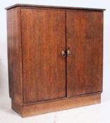 A 1950's solid oak school cupboard raised on plinth base with twin doors having single shelf within