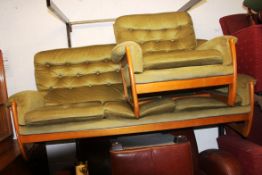 A retro wooden framed 1960's three seat sofa and matching chair in the manor of G-Plan