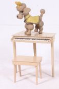 A vintage 1950's childs piano and stool in original finish together with a bendy composite dog.