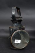 An early 20th century railway lamp / lantern with glass lens to front,