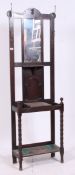 An early 20th century small proportioned oak hall stand with mirror and hooks over central glove