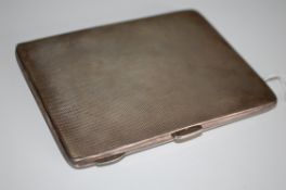 A large hallmarked silver engine turned cigarette case marked for J.