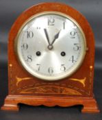 An Edwardian mahogany inlaid 8 day mantel clock in working order complete with the key.