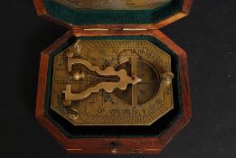 A vintage style brass cased sundial and compass within a wooden case