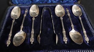 A silver hallmarked cased set of apostle  teaspoons and sugar tongs  by MW with Sheffield hallmarks