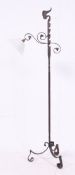 An adjustable wrought iron scratch built standard lamp having a later fitted retro pendant light