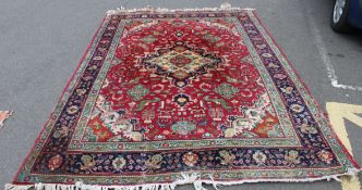 A large 20th century Persian / Islamic rug having red ground with central medallions having