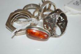 A collection of 8 silver and white metal ladies dress rings, one being set with amber.