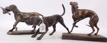 A collection of three cast metal bronze effect statues of dogs. Some with hand painted features.