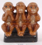 A novelty metal money box in the form of the three wise monkeys