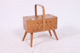 A 1950's metamorphic retro folding sewing box with hinged compartments - with contents