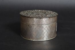 A 19th century silver trinket box of cylindrical form with chased decoration having an inset copper