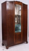A 1930's Art Deco oak single wardrobe having shaped top with central mirror door having hanging