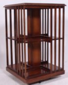 An Edwardian mahogany inlaid revolving bookcase having twin tiers with slatted sides raised on