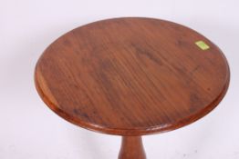 A 19th century elm wood tilt top tripod wine table.