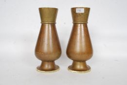 A pair of early 20th century heavy brass vases of fluted form with circular bases