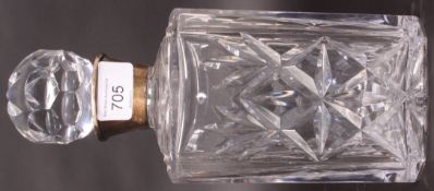 A cut glass decanter with stopper having a silver hallmarked silver collar