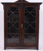 An Edwardian oak and leaded glass display cabinet.