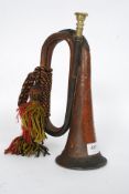 A military copper bugle complete with notation to the top having rope tassels and ties
