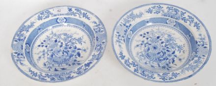 A pair of 19th century blue and white soup plates with central flower basket design having unusual