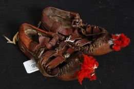 A pair of Hungarian decorative leather childrens shoes with leather tassels etc