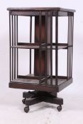 A 20th century solid oak revolving bookcase having castors to quadruped base with slatted sectional