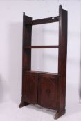 An oak bookcase of Spanish origin with adjustable shelves raised over double door cupboard H192 W90