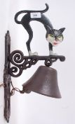 A 20th century cast iron wall hanging bell and bracket, in the form of a cartoon like cat.