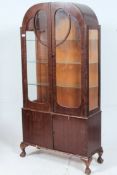 A 1930's Art Deco walnut veneer display cabinet raised on cabriole legs with pad feet having glass
