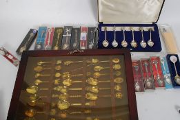A collection of collectors spoons from around the world many still boxed along with display cabinet